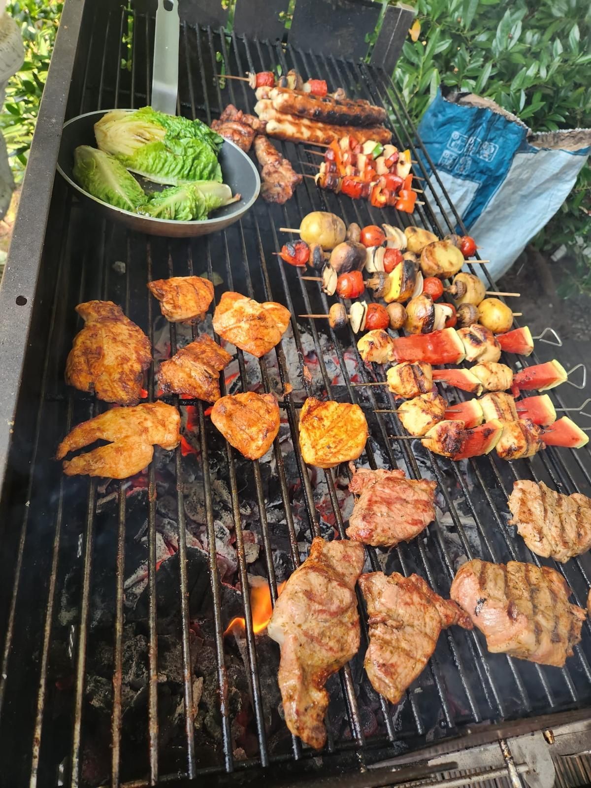Auswahl an Grillgerichten vom Grill: Fleisch, Gemüsespieße und Salat.