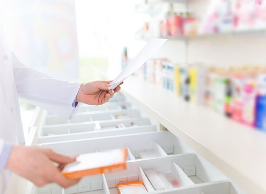 Un farmacéutico está mirando una receta en una farmacia.