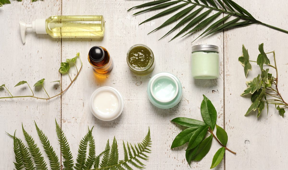 Hay muchos tipos diferentes de cosméticos y hojas sobre la mesa.