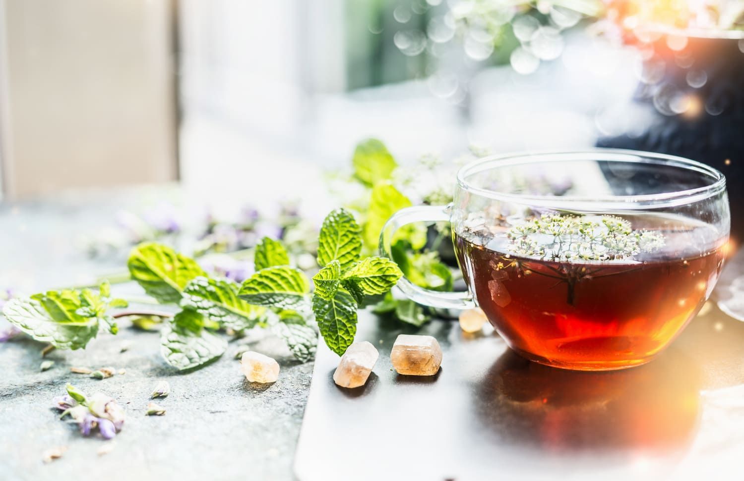 Una taza de té con hojas de menta sobre una mesa.
