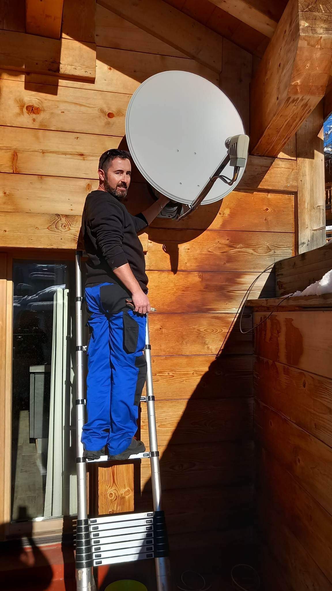 Technicien qui oriente une parabole