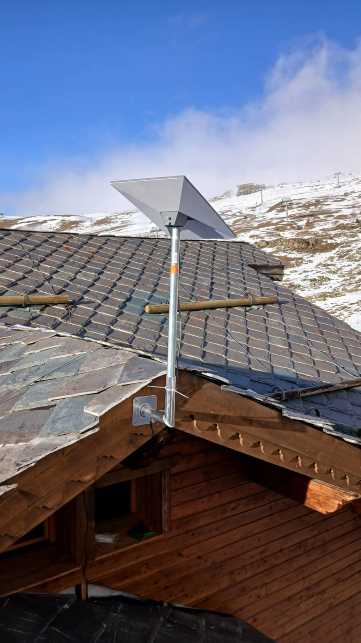 Parabole sur le toit d'un chalet en bois