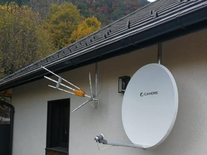 Antenne et parabole fixées toutes les deux sur une maison