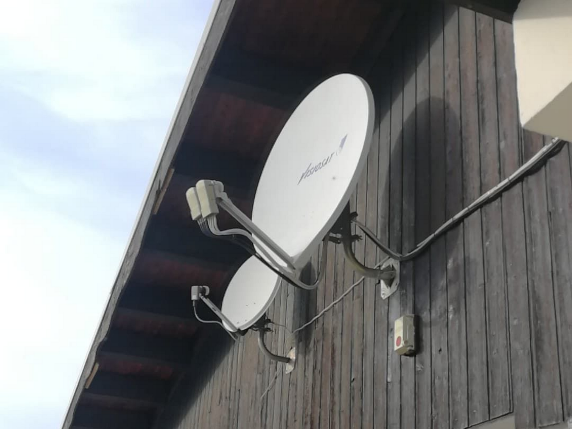 Deux paraboles sur une façade de chalet en bois