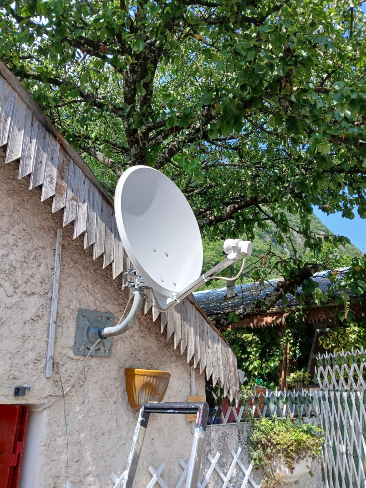 Une parabole TV sur le mur d'une façade de maison