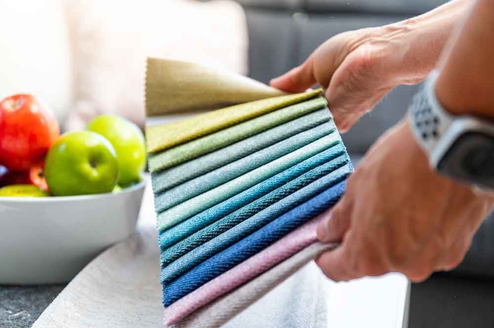 eine Person hält eine Auswahl an Stoffen in ihren Händen .