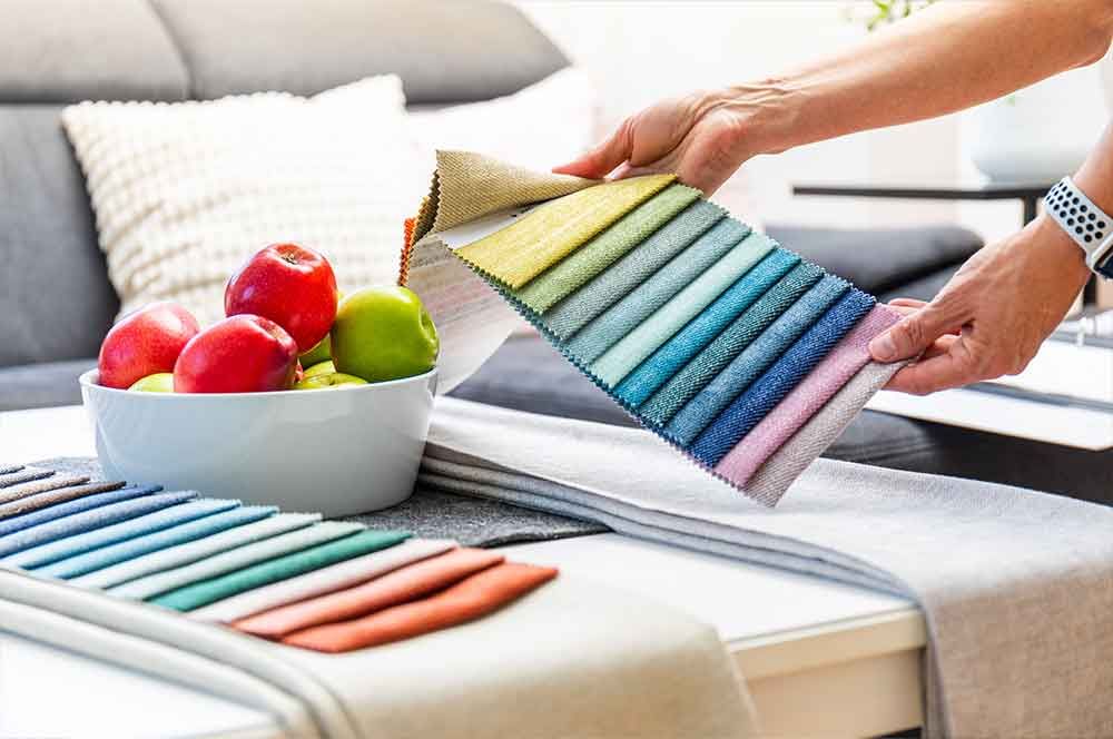 Eine Person hält eine Auswahl an Stoffen in ihren Händen .