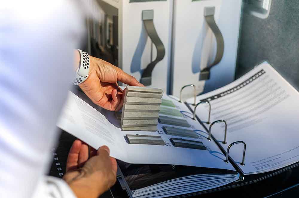 Eine Person hält ein Stück Papier in der Hand und legt es in einen Ordner .