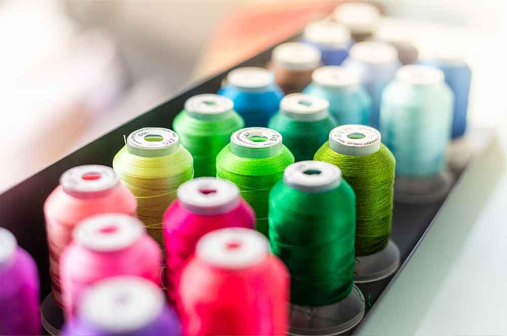 eine Schachtel mit vielen verschiedenen farbigen Garnsträngen .