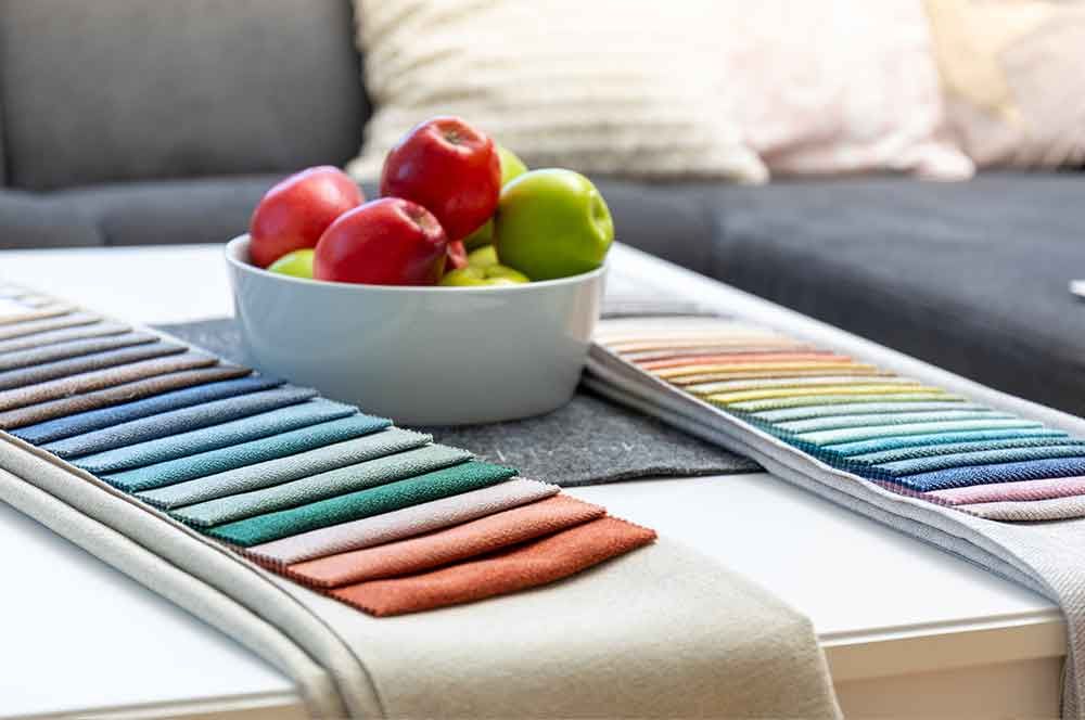 Auf einem Couchtisch steht eine Schüssel mit Äpfeln .