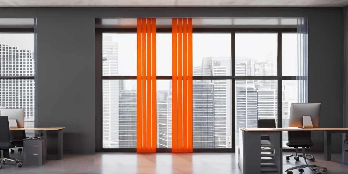 ein Büro mit grauen Wänden und orangefarbenen Vorhängen .