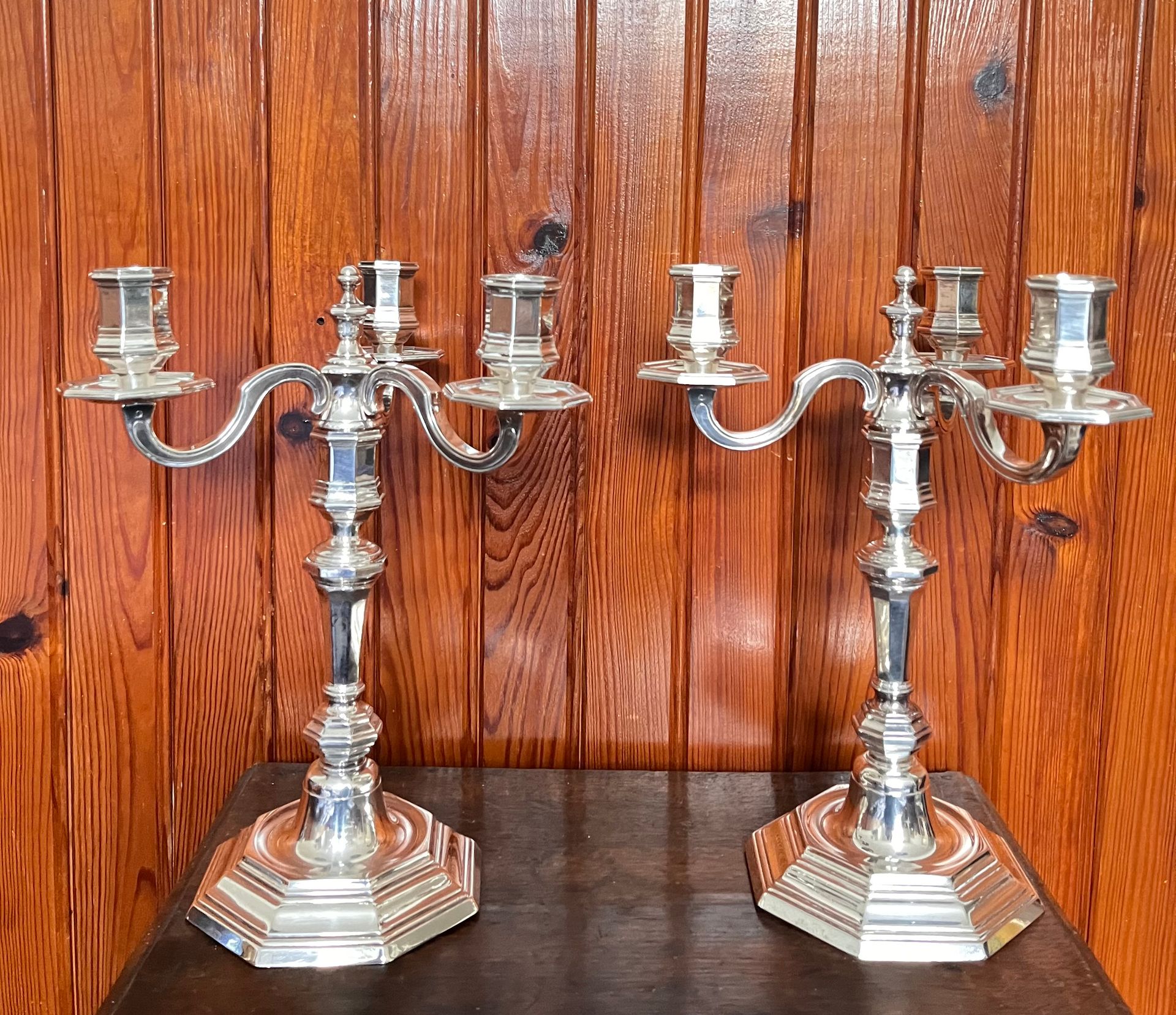 Deux chandeliers devant un mur en lambris