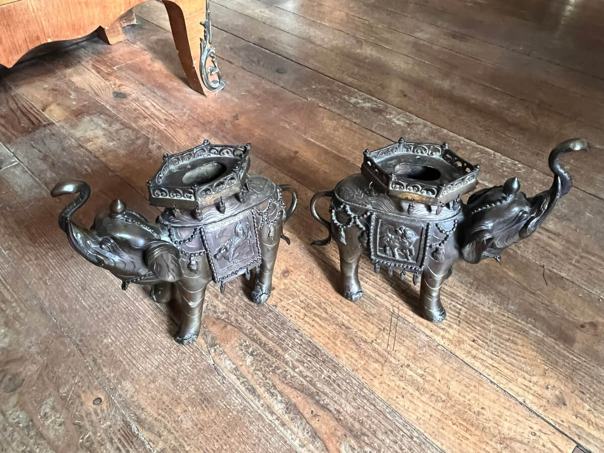 Deux bougeoirs en bronze ornés en forme d'éléphant sur une surface en bois.