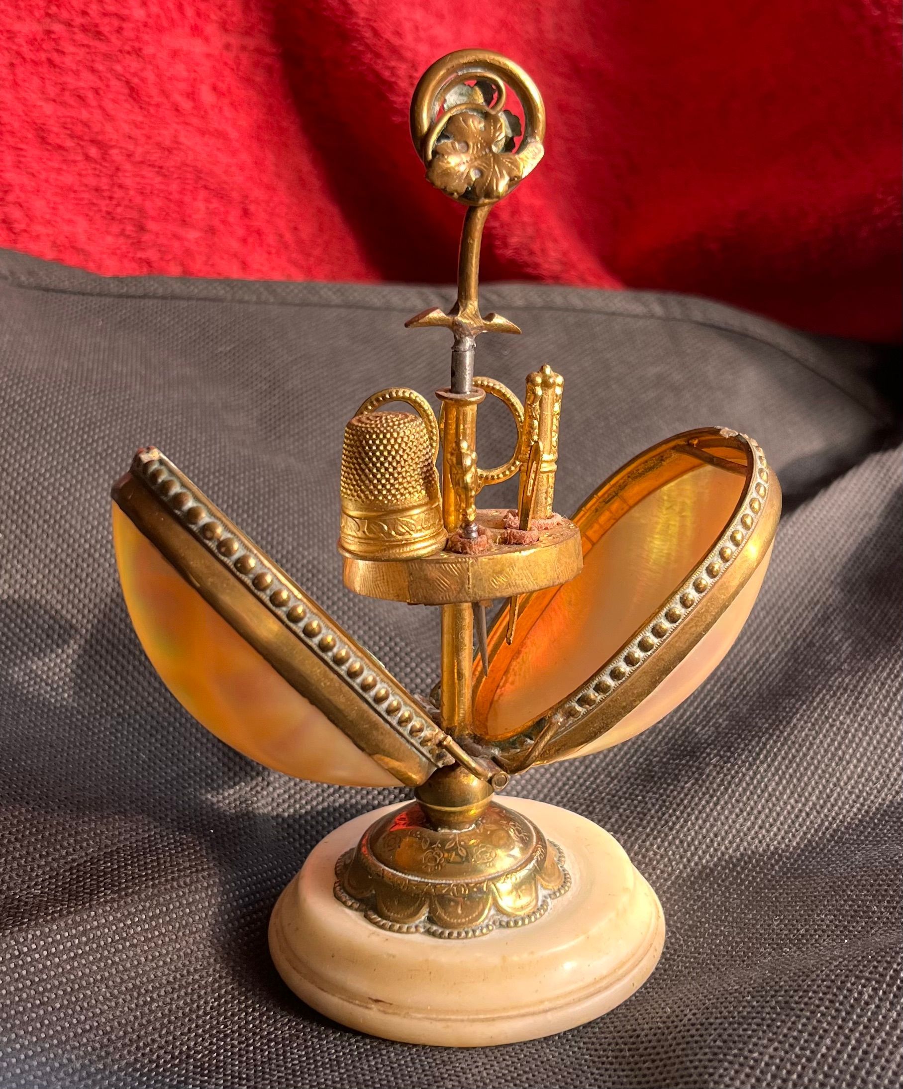 Petit objet dorée en forme d'œuf qui s'ouvre