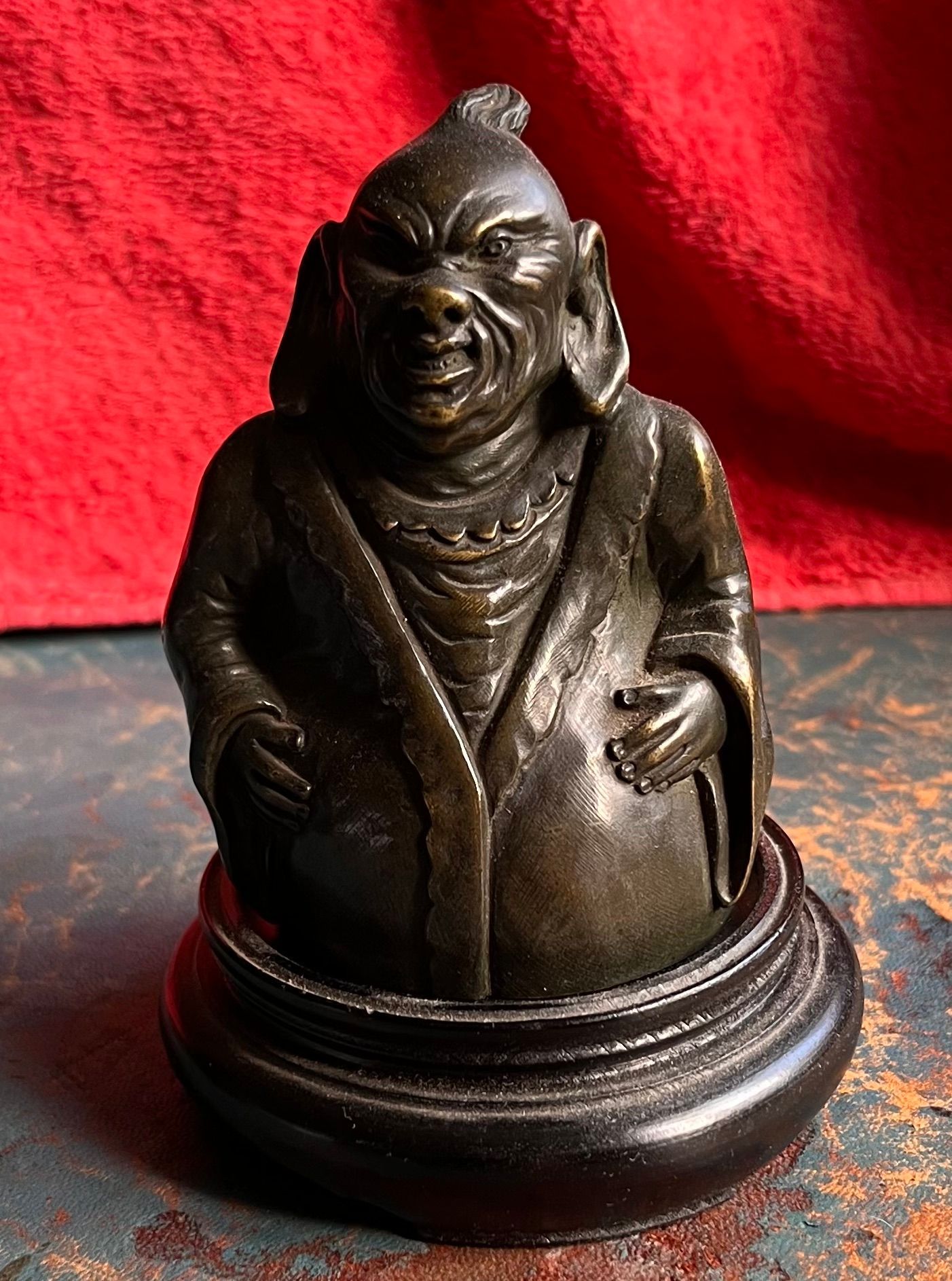 Statue gris foncée d'un personnage à l'air énervé