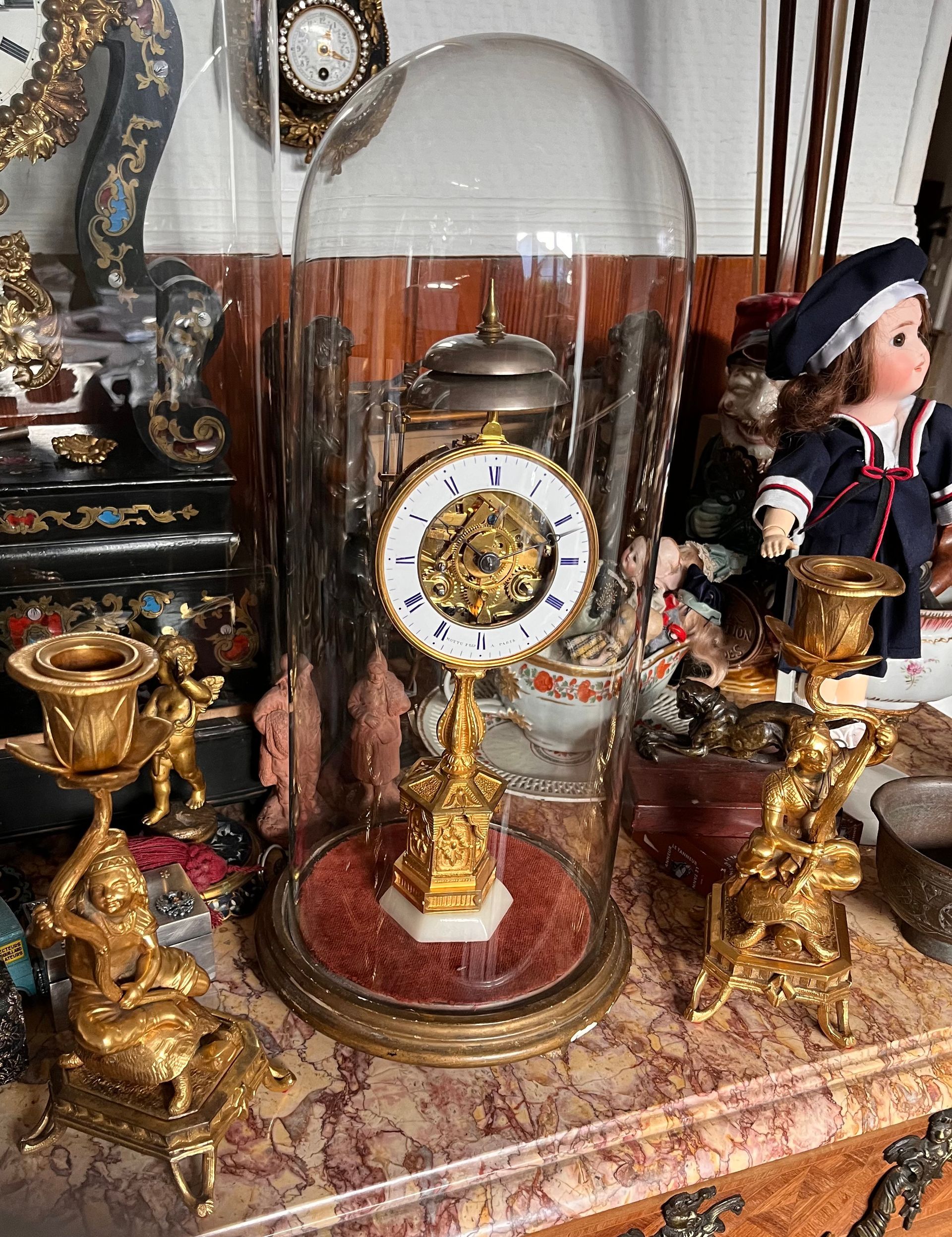 Ancienne horloge dorée sous cloche en verre