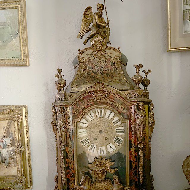 Horloge ancienne, un ange doré surplombe le produit.