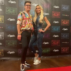 Un hombre y una mujer están parados uno al lado del otro en una alfombra roja.