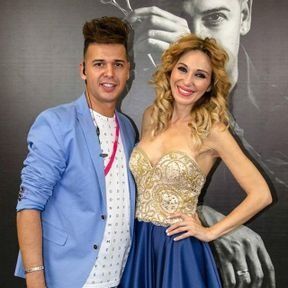 Un hombre y una mujer posan para una foto frente a un hombre que sostiene un par de tijeras.