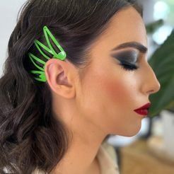 Una mujer lleva una horquilla verde en el pelo.