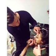 Un hombre está aplicando maquillaje en la cara de una mujer.