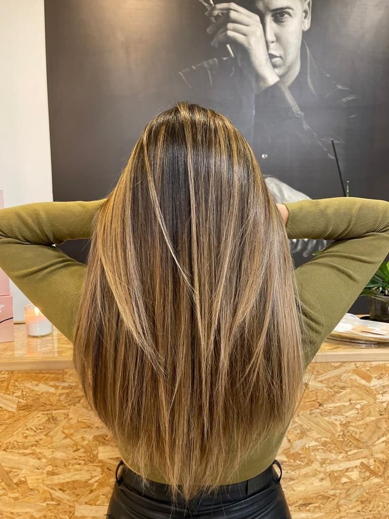 Una mujer con cabello largo está parada con los brazos extendidos frente a una fotografía de un hombre.