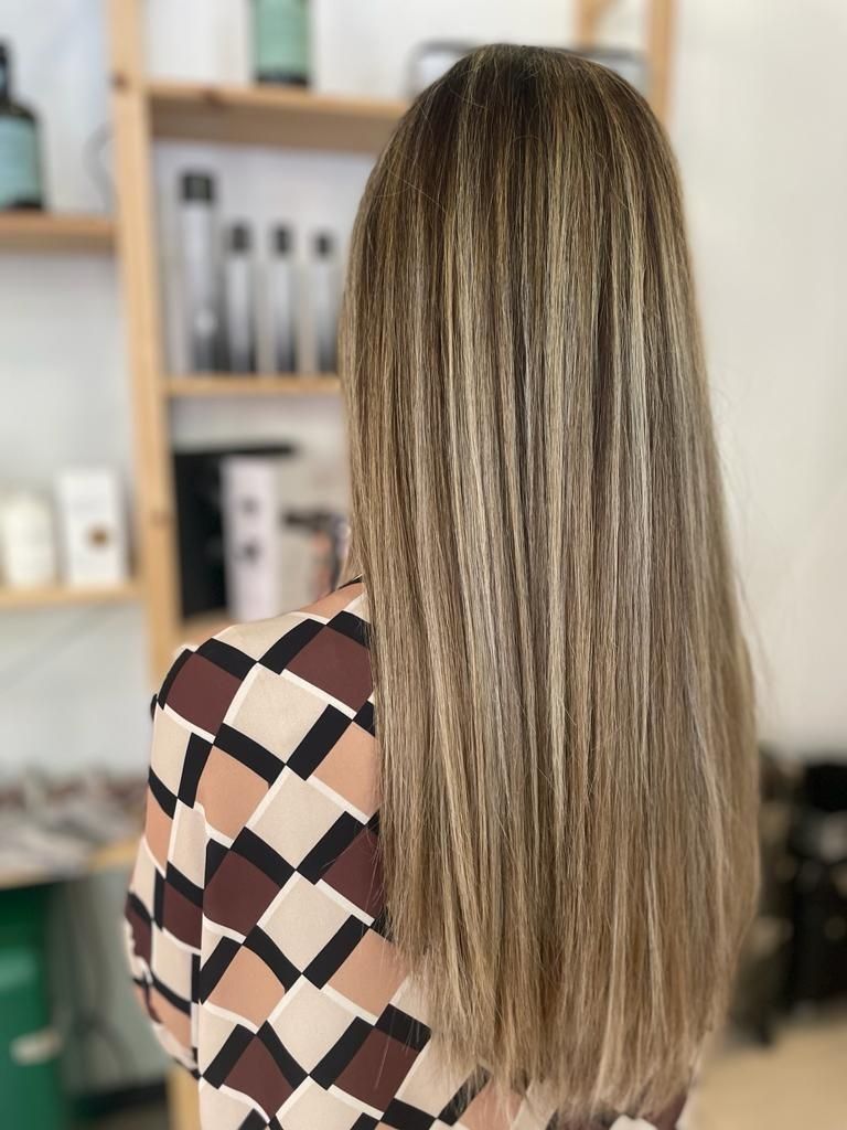 Una mujer con cabello largo lleva una camisa a cuadros.