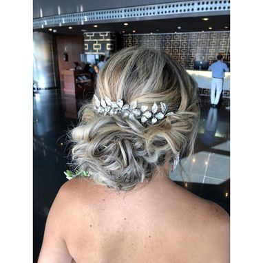 La espalda de una mujer que lleva un moño con un peine en el pelo.