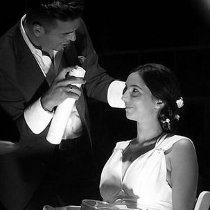 Un hombre está rociando el cabello de una mujer en una foto en blanco y negro.