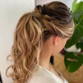 Una mujer lleva el pelo recogido en una cola de caballo.