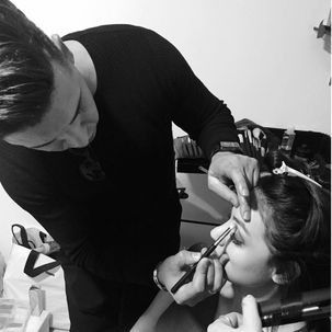 Un hombre está aplicando maquillaje en la cara de una mujer.