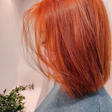 Una mujer con cabello rojo lleva una camisa azul.