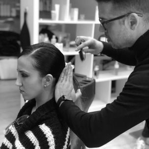 Un hombre está peinando el cabello de una mujer en una fotografía en blanco y negro.