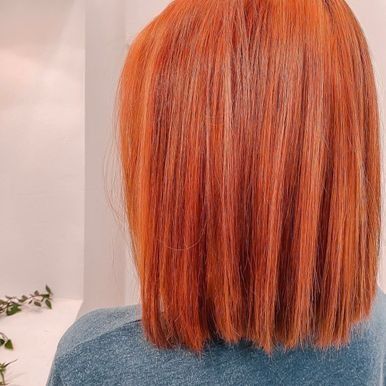 Una mujer con cabello rojo lleva una camisa azul.