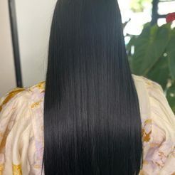 La parte posterior de la cabeza de una mujer con cabello largo y negro.