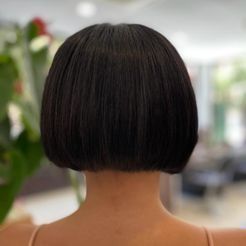 Se muestra la espalda de una mujer con cabello corto.
