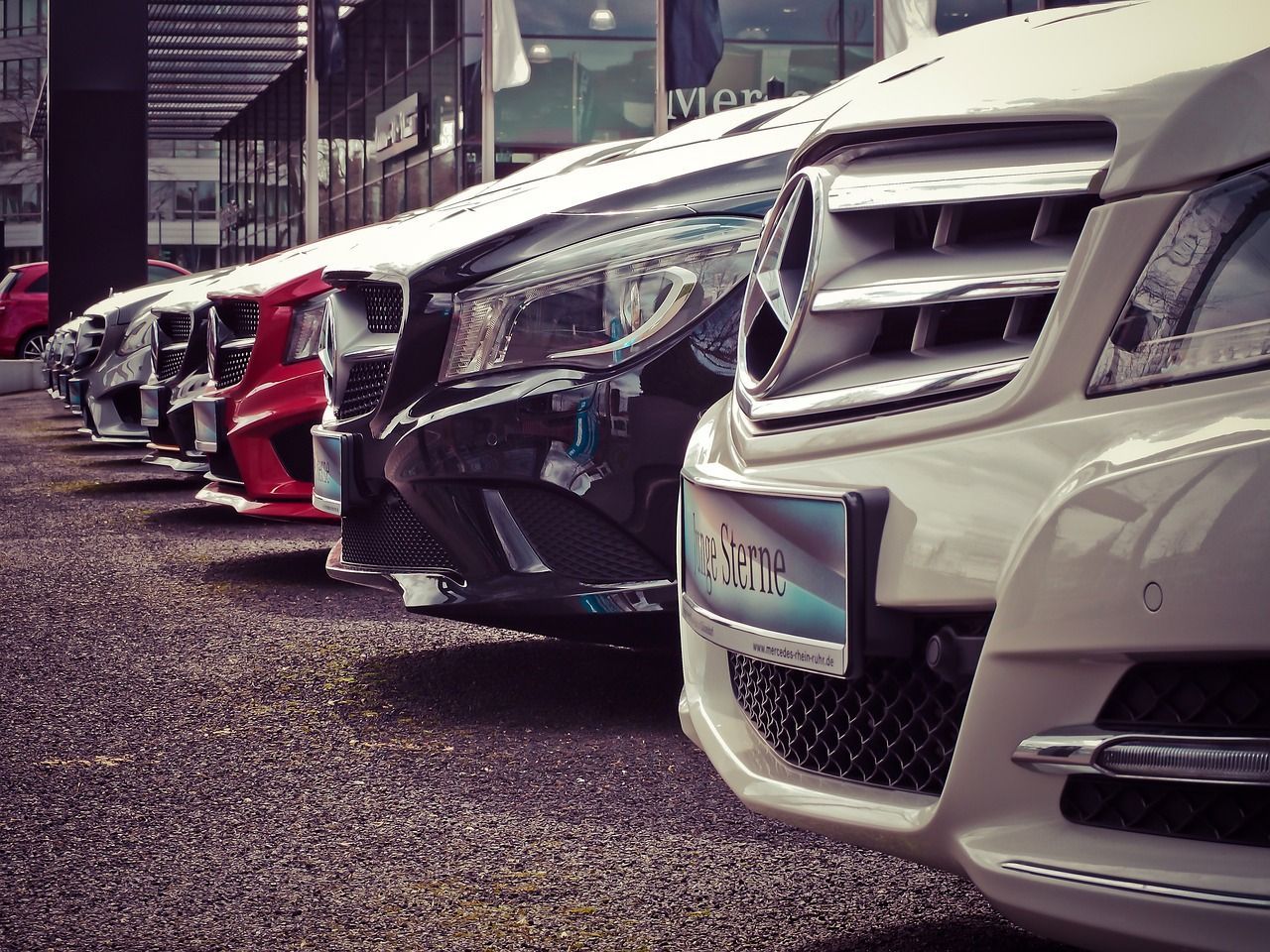Una fila de coches están aparcados uno al lado del otro en un estacionamiento.