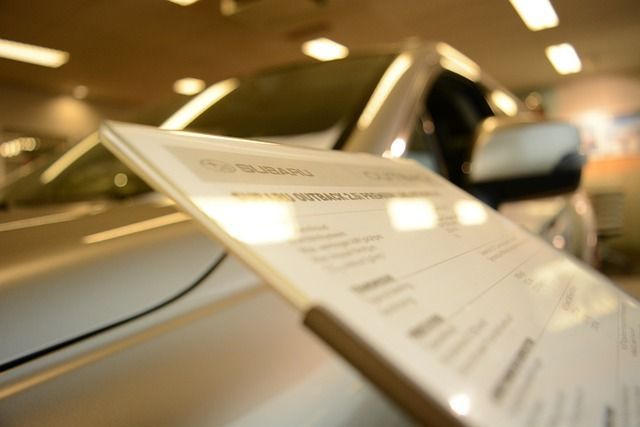 Un coche se exhibe en una sala de exposición con un cartel delante.