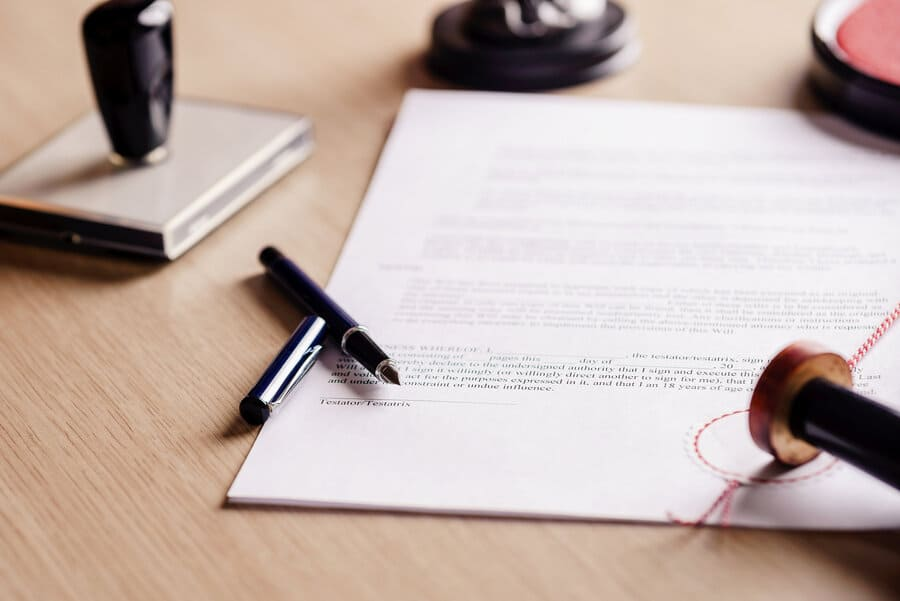 Una persona está firmando un documento con un sello en él.