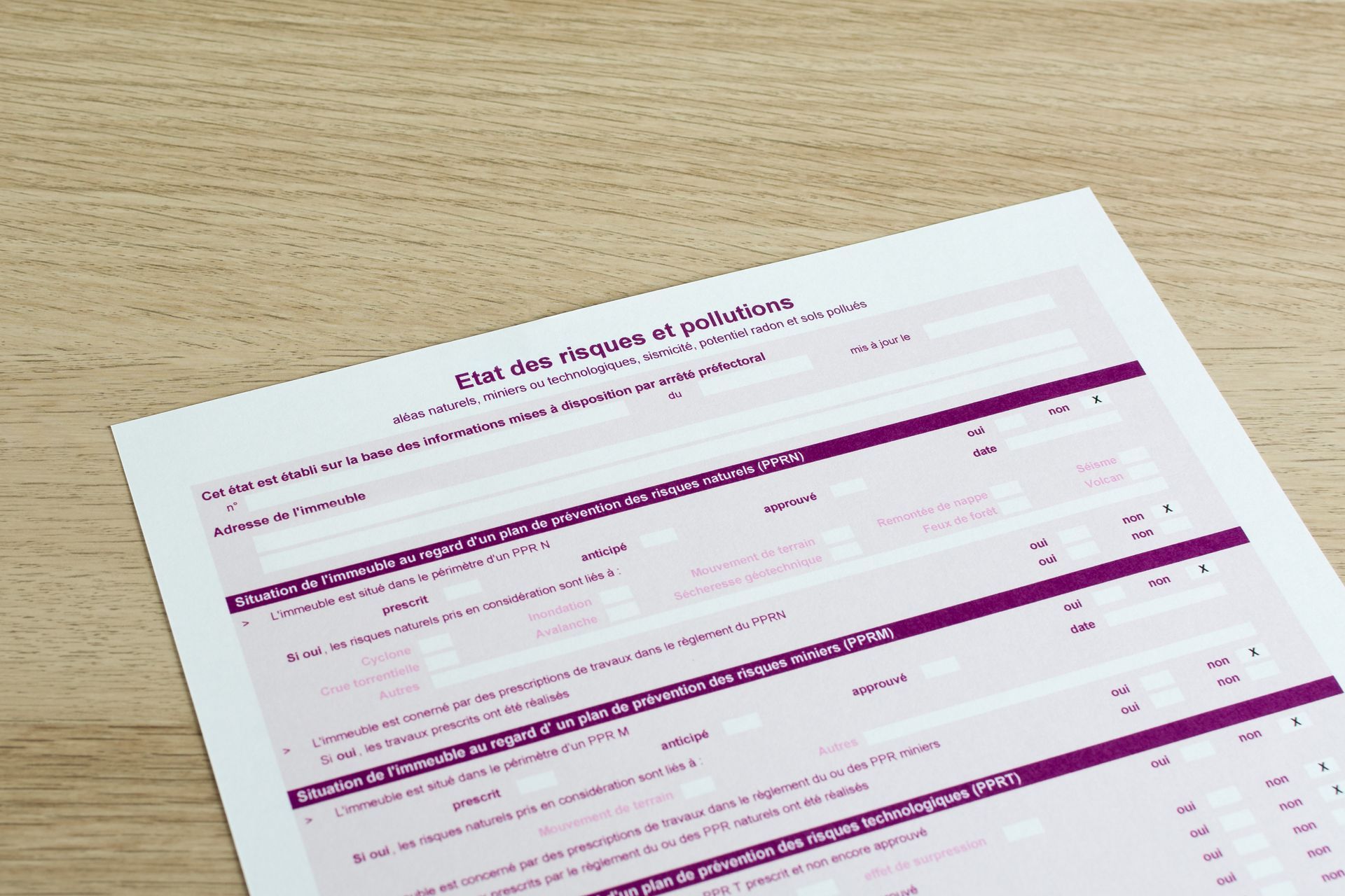 Un formulaire ERP (État des risques et pollution) posé sur un bureau en bois clair.