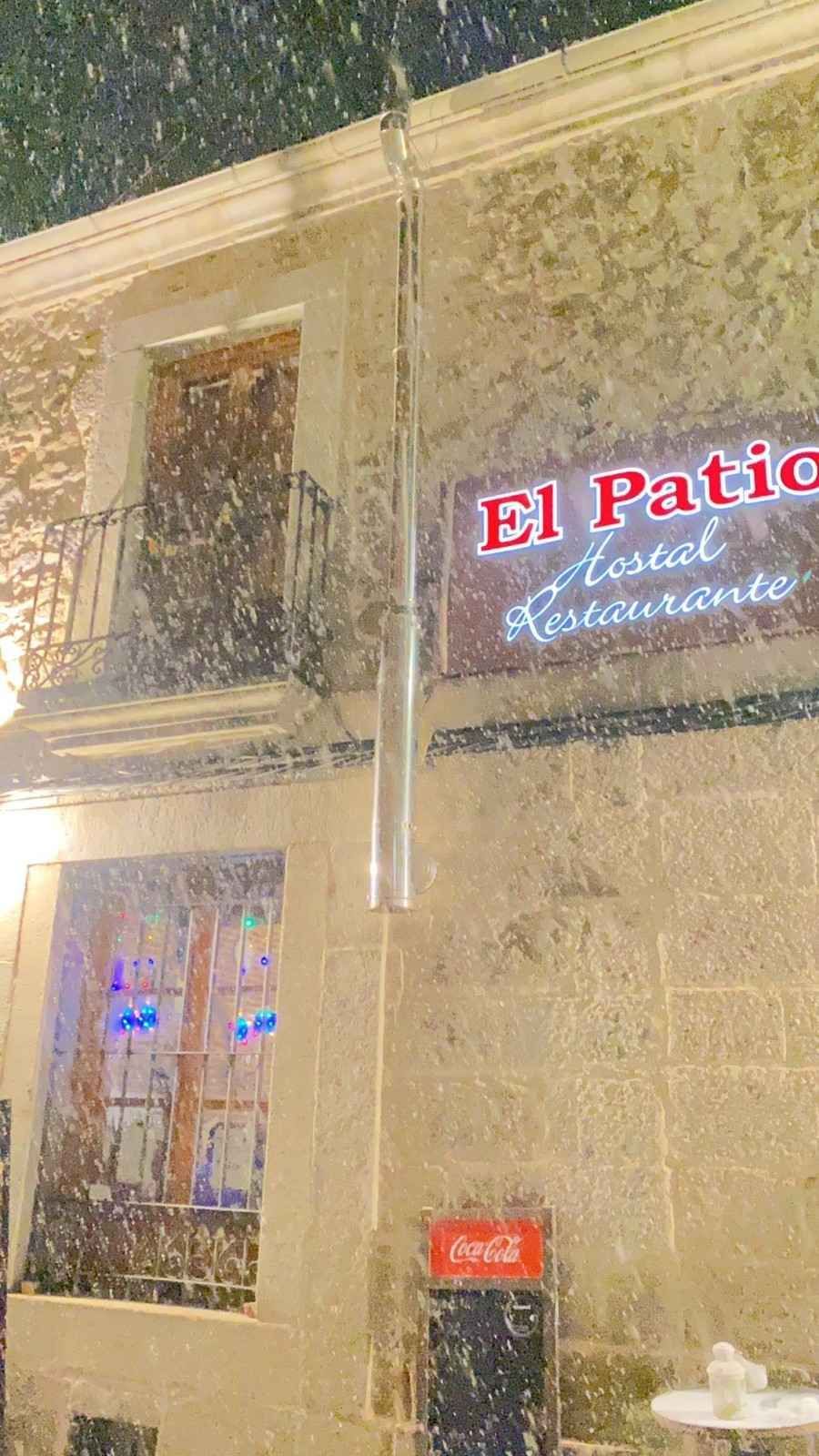 Vista nocturna de un edificio beige con un letrero de neón que dice