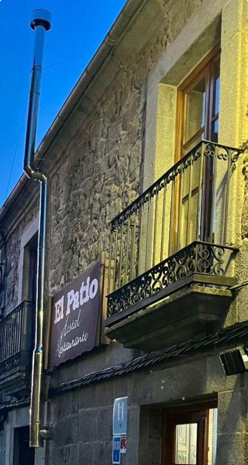 Fachada de edificio de piedra con balcón negro y letrero de “The Malt” bajo un cielo azul.