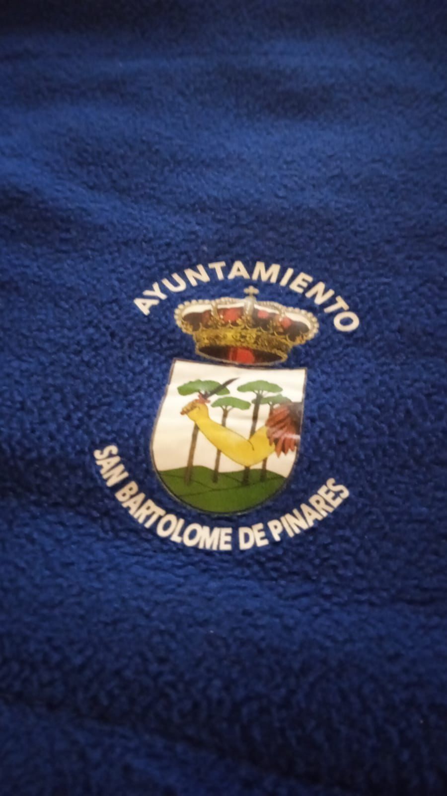Blue fabric with the Ayuntamiento San Bartolomé de Pinares embroidered crest and text