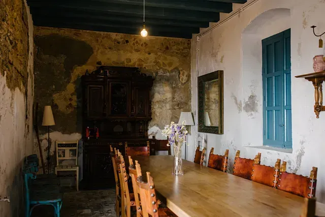 Hay una mesa larga de madera y sillas en la habitación.