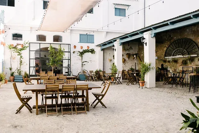 Un patio con mesas y sillas frente a un edificio.