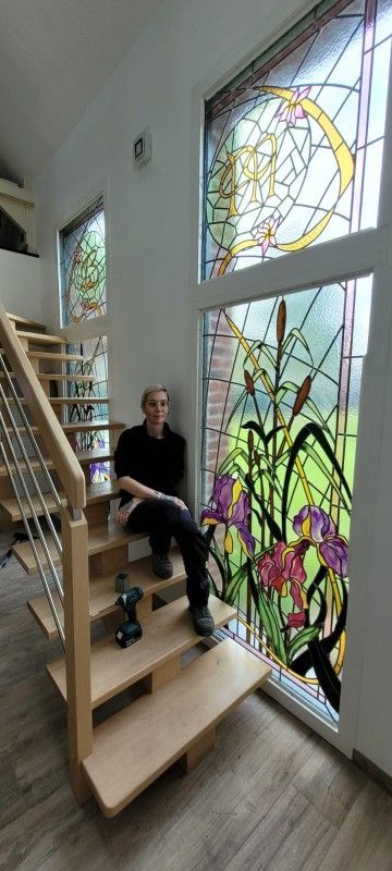 Patricia à côté d'un vitrail aux motifs fleuris