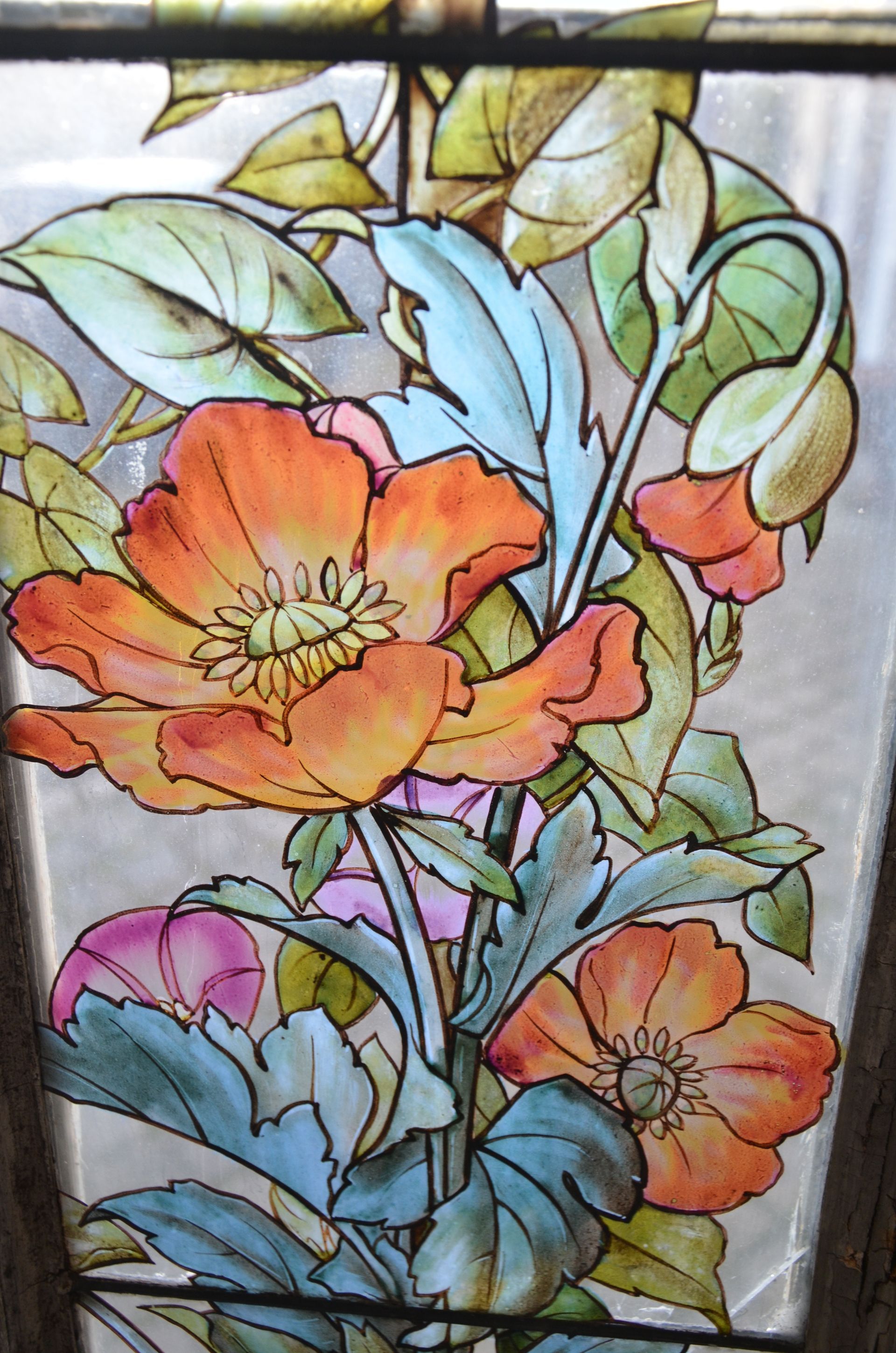 Mélange de fleurs et d'écussons sur un vitrail