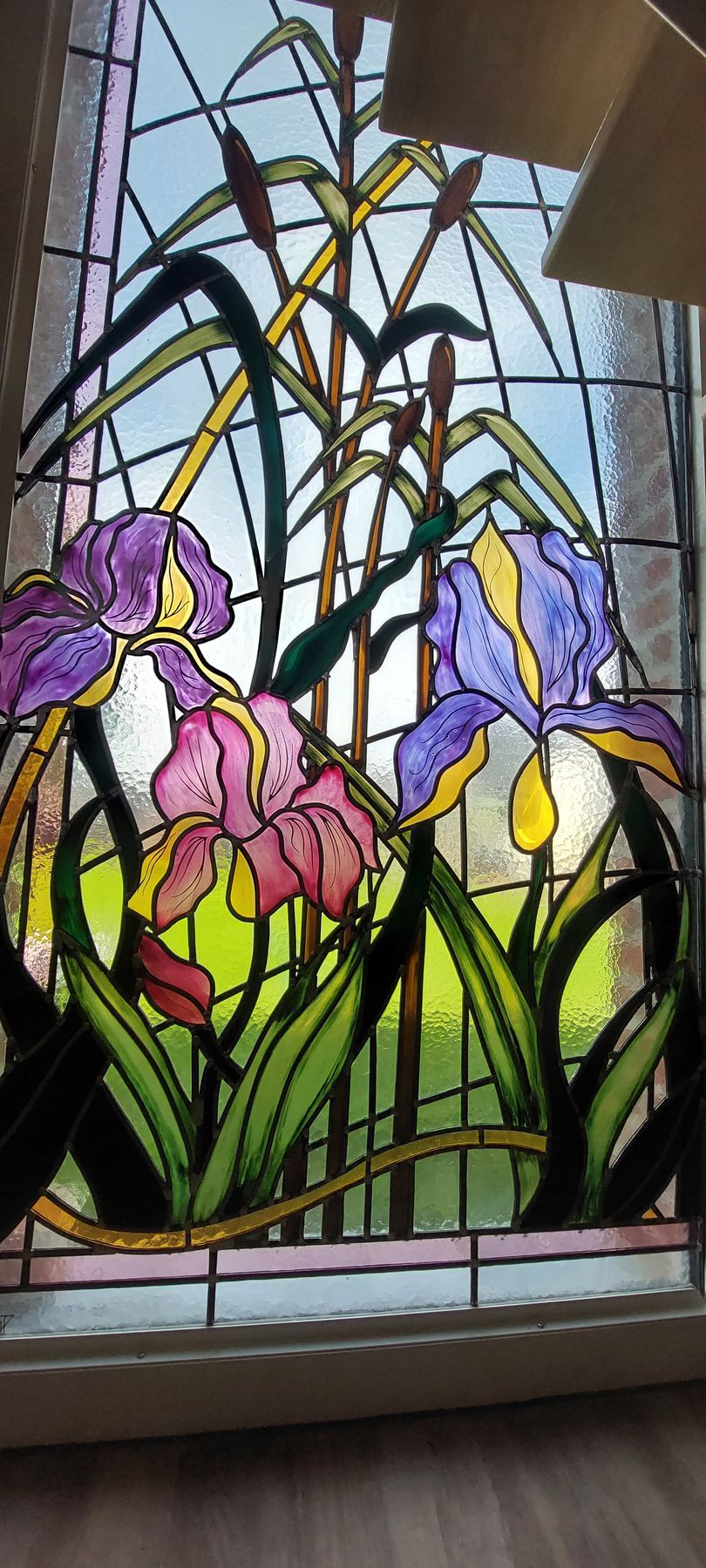 Gros plan sur un vitrail aux motifs fleuris