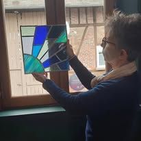 Une stagiaire et son vitrail à formes géométriques