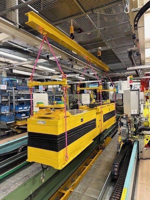 Gelbes industrielles Transportsystem, das in einer Fabrik an einem Balken hängt.